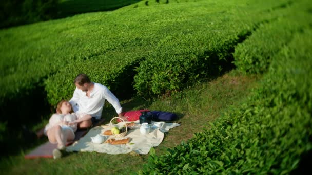 Encontro romântico de um casal agradável homem e mulher em uma clareira entre uma plantação de chá. conceito de viagem, lazer. Estilo de vida. 4k . — Vídeo de Stock