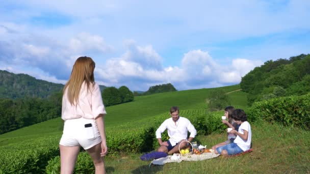 Aile piknik bir çay plantasyon arasında bir açıklıkta. seyahat, rekreasyon kavramı. yaşam tarzı. 4k. — Stok video