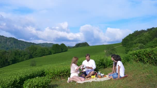 Un pique-nique familial dans une clairière au milieu d'une plantation de thé. concept de voyage, de loisirs. style de vie. 4k . — Video