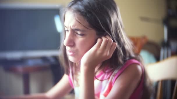 Kis lány barna, hosszú haj, a fejhallgató, énekel dalokat számítógép előtt ül. 4k, lassú mozgás — Stock videók