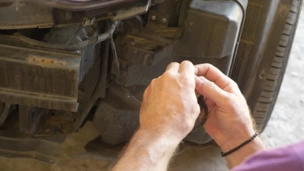 Закрывай. механика руки, который снимает бампер автомобиля, он ремонтирует машину. 4k — стоковое видео