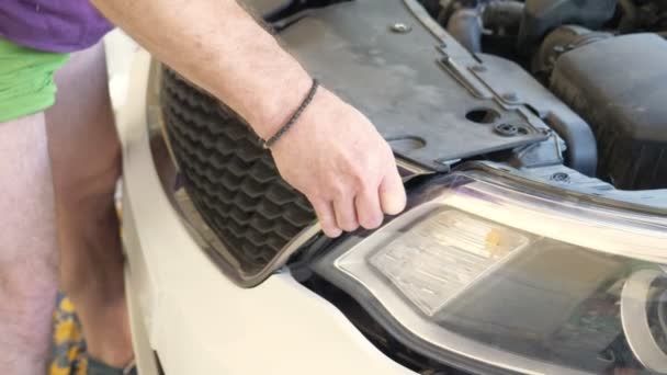 De près. des mains des mécaniciens, qui enlève le pare-chocs de la voiture, il répare la voiture. 4k — Video