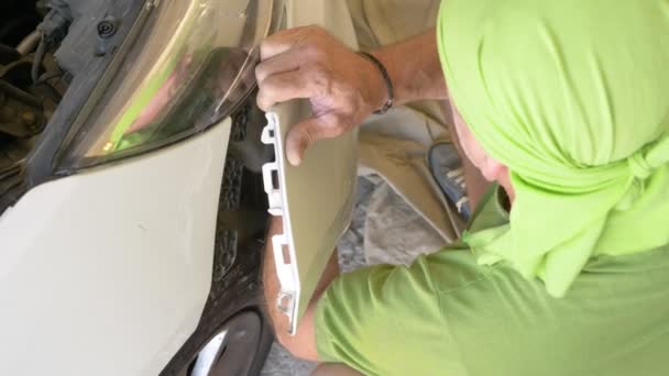De cerca. de las manos de los mecánicos, que quita el parachoques del coche, que repara el coche. 4k — Vídeos de Stock