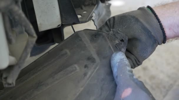 De près. des mains des mécaniciens, qui enlève le pare-chocs de la voiture, il répare la voiture. 4k — Video