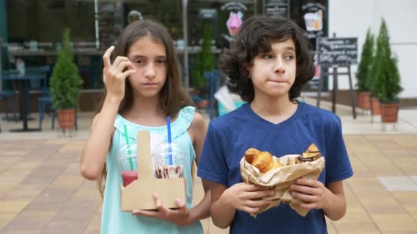 Dospívající dívka a chlapec opustí cukrárna s croissanty, kobliha a smoothie pro společnost přátel. rozostření, detail. 4k, zpomalené. s sebou — Stock video