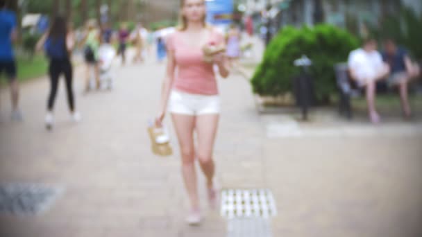 La chica sale de la pastelería con croissants, un donut y café para una compañía de amigos. Borroso, primer plano. 4k, cámara lenta. para llevar — Vídeo de stock