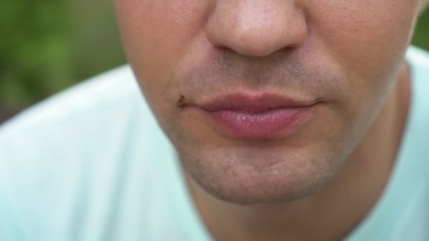 ハンサムな男は、おいしいクロワッサンを食べながら幸せそうに見えます。唇のクローズ アップ。4 k スローモーション — ストック動画