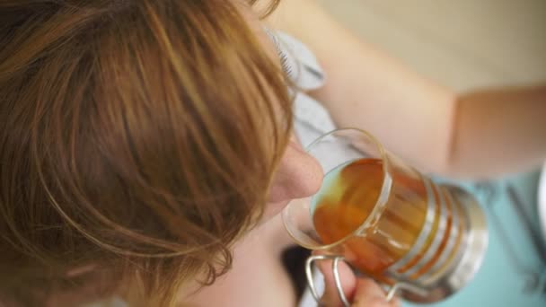 La chica está bebiendo té con Sitting en un café de verano. Vidrio transparente . — Vídeos de Stock