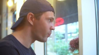 Genç adam suşi çubukla yemek Cafe. 4k, yakın çekim.