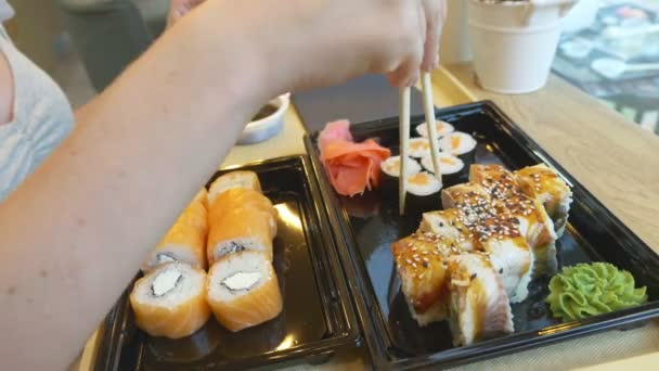箸で寿司を食べてカフェで、若い女性。4 k、クローズ アップ. — ストック動画
