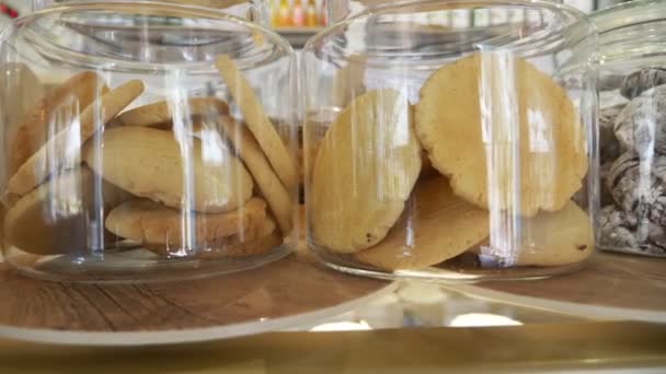 Biscuits dans des bocaux en verre dans une vitrine de confiserie. 4k, au ralenti — Video