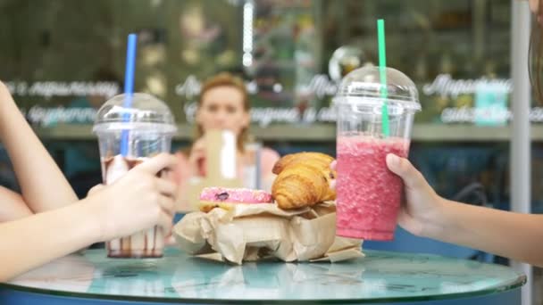 Pequeno-almoço útil. close-up, mãos batem copos com fresco no fundo de um café de rua. pastelaria fresca na mesa. 4k, câmera lenta . — Vídeo de Stock