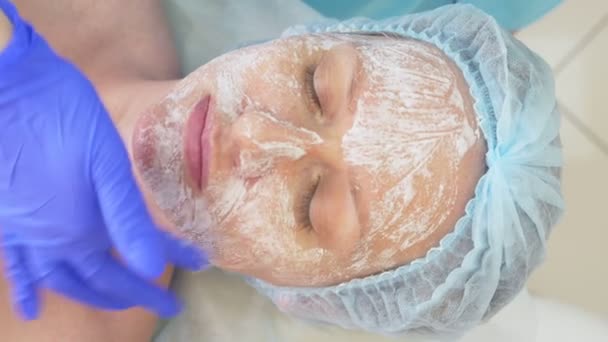 Крупним планом процедура краси. Косметолог чистить маску для обличчя. Пілінг. Догляд за шкірою тіла та краси. повільний рух 4k — стокове відео