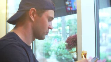 Genç adam suşi çubukla yemek Cafe. 4k, yakın çekim.