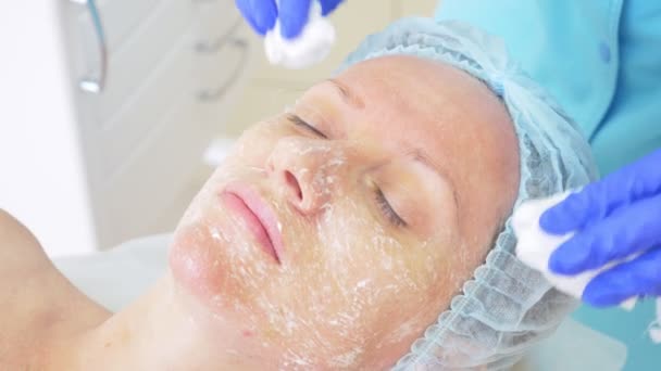 Zbliżenie piękna procedury. Kosmetyczka czyszczenia twarzy maskę. Peelingu. Pielęgnacja skóry ciała i urody. zwolnionym tempie 4k — Wideo stockowe