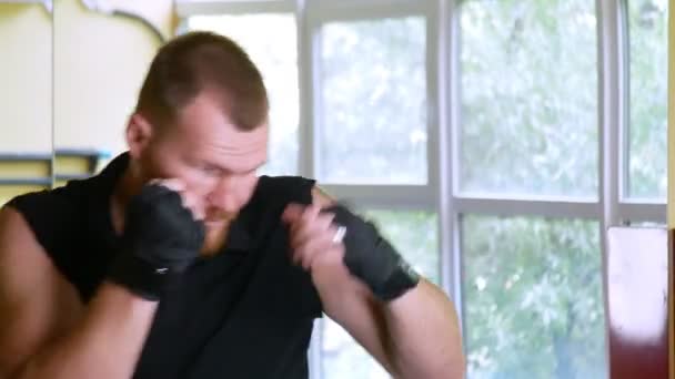 Als Profisportler trainiert ein Boxer in der Kampfsporthalle. junger europäischer Mann in der Turnhalle. 4k, — Stockvideo