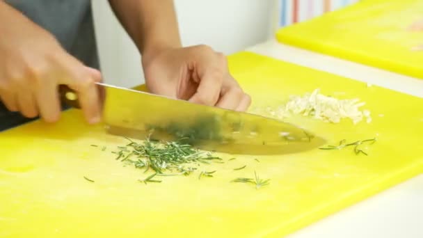 Masterclass over koken. Kinderen maaltijden met een professionele chef-kok in de keuken. 4 k. gesneden uien en rozemarijn op een snijplank. — Stockvideo