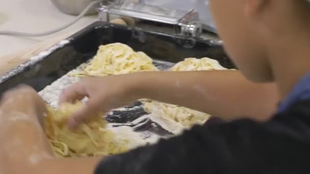 Erişte yapmak. Spagetti ile geleneksel tarzda makarna makinesi. Pişirme işlemi. 4 k. yakın çekim. Şef kullanmak pasta kesme makinesi. — Stok video