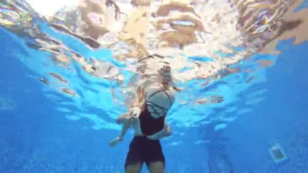 4k. Vue sous l'eau. Un couple d'hommes et de femmes, nageant ensemble sous l'eau . — Video