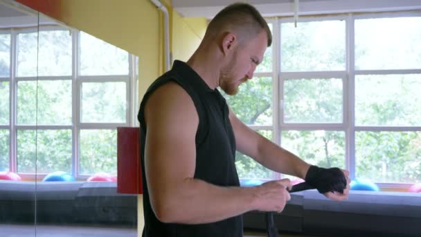 Un atleta boxeador profesional entrena en la sala de artes marciales. joven europeo en el gimnasio, con una camiseta con un entrenador de inscripción. 4k, cámara lenta , — Vídeos de Stock