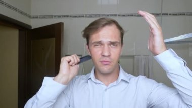 Genç çekici adam uzaklaşıyorsun saç çizgisi banyoda olup olmadığını denetler. Kellik