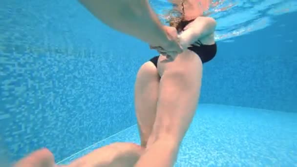 4k. Vue sous l'eau. Un couple d'hommes et de femmes, nageant ensemble sous l'eau . — Video