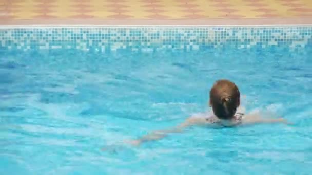 Sexy Frau im schwarzen Badeanzug schwimmt im Pool. Zeitlupe. 4k. — Stockvideo