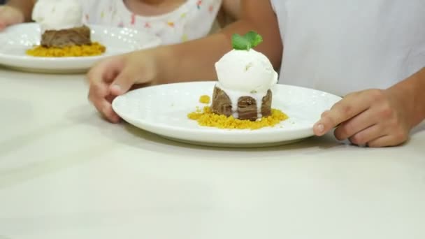 Close-up. 4 to. Childrens hands in a cafe are eating a chocolate fountain dessert. — Stock Video