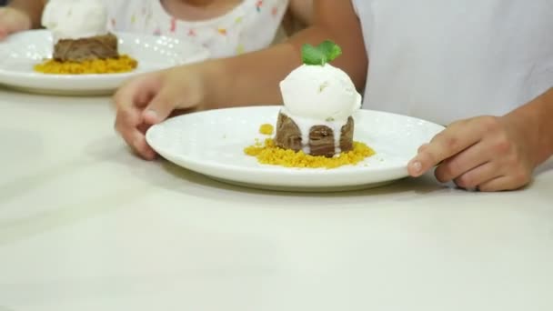 Primo piano. 4 a. Le mani da bambini in un caffè stanno mangiando un dessert alla fontana di cioccolato . — Video Stock