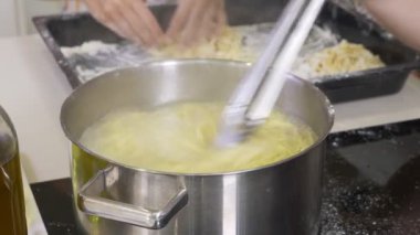 Erişte yapmak. Spagetti ile geleneksel tarzda makarna makinesi. Pişirme işlemi. 4 k. yakın çekim. Şef kullanmak pasta kesme makinesi.
