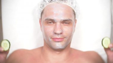 Yakışıklı erkekler yüz maskesi alma için spa terapisi. 4 k. ağır çekim. Bir güzellik uzmanı alımı