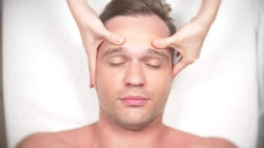 Adam bir yüz almak masaj. Yüz ve boyun masaj. kasmetologist ofiste yalan. 4k, yavaş hareket, görünümü top