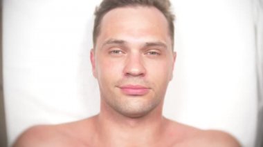 Adam bir yüz almak masaj. Yüz ve boyun masaj. kasmetologist ofiste yalan. 4k, yavaş hareket, görünümü top