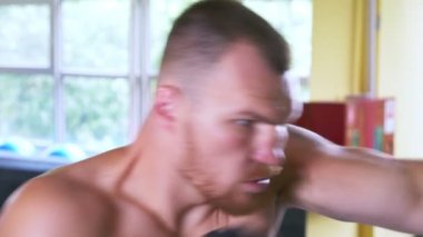 Bir profesyonel boksör sporcu dövüş sanatları salonunda eğitiyor. Avrupa Genç spor salonunda. 4k, ağır çekim,