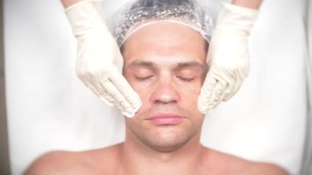 Terapia de spa para hombres guapos que reciben máscara facial. 4k. En cámara lenta. Recepción de un cosmetólogo — Vídeos de Stock