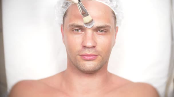 Terapia de spa para hombres guapos que reciben máscara facial. 4k. En cámara lenta. Recepción de un cosmetólogo — Vídeos de Stock