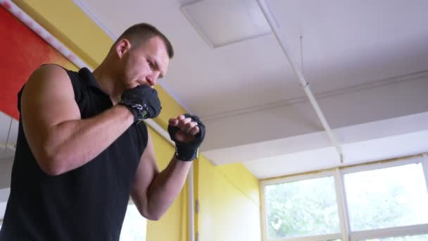 Un atleta boxeador profesional entrena en la sala de artes marciales. Un joven europeo en el gimnasio. 4k, cámara lenta , — Vídeos de Stock