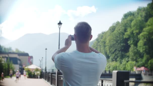 Ο άνθρωπος χρησιμοποιώντας το smartphone, το περπάτημα στην πόλη μια καυτή ηλιόλουστη ημέρα. Ταξίδια. Η έννοια του έναν τρόπο ζωής. gadget της σύγχρονες τεχνολογίες επικοινωνιών. 4k, αργή κίνηση — Αρχείο Βίντεο