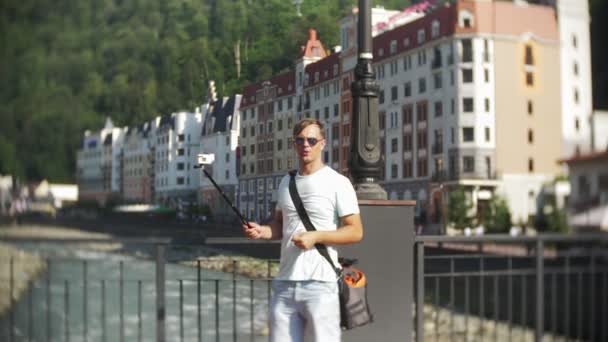 Uomo, blogger con una macchina fotografica, a piedi in città in una calda giornata di sole. Viaggia. Il concetto di uno stile di vita. gadget delle moderne tecnologie di comunicazione. 4k, rallentatore — Video Stock