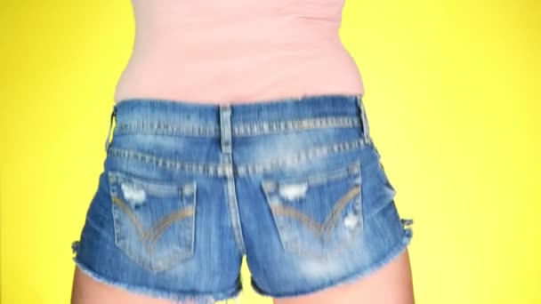 Meisje in korte broek de korte jeans blauw. Close-up beeld van achteren. Zomer frisse stijl. 4k, slow-motion — Stockvideo