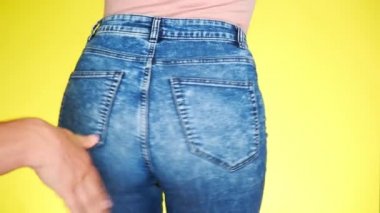 bir erkek el kızlar Kalça tokat. kız kot pantolon seductively taşır. 4k, yakın çekim. ağır çekim