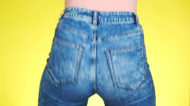 Ein Mädchen in Jeans mit schönem rundem Gesäß ist sexuell bewegend. Nahaufnahme. 4k, Zeitlupe — Stockvideo