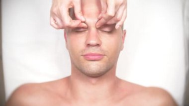 Adam bir yüz almak masaj. Yüz ve boyun masaj. kasmetologist ofiste yalan. 4k, yavaş hareket, görünümü top