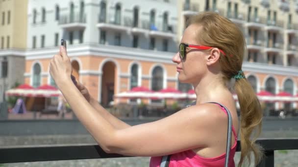 Nő használ smartphone séta a városban, egy forró napsütéses napon. Utazás. A koncepció egy út-ból élet. a modern kommunikációs technika gadget. 4k, lassú mozgás — Stock videók