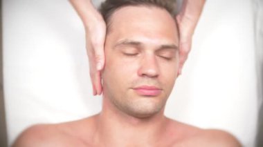 Adam bir yüz almak masaj. Yüz ve boyun masaj. kasmetologist ofiste yalan. 4k, yavaş hareket, görünümü top