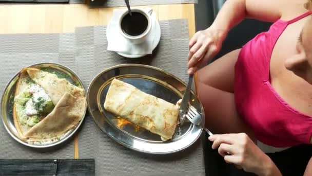 Люди едят фаршированные блинчики в кафе. 4k, slow motion . — стоковое видео