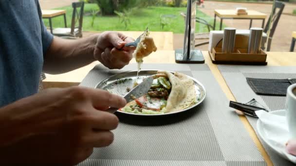 Mensen eten gevulde pannenkoeken in een café. 4k, slow-motion. — Stockvideo