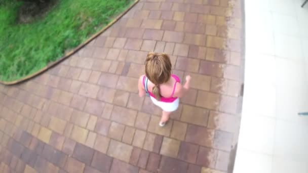 Θέα από ψηλά. 4 k. την κάμερα δράσης. Μια γυναίκα βόλτες στο πάρκο σε μια καλοκαιρινή μέρα βροχερή. — Αρχείο Βίντεο