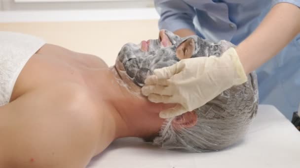 Thérapie spa pour les beaux hommes recevant un masque facial. 4k. Au ralenti. Accueil d'un cosmétologue — Video