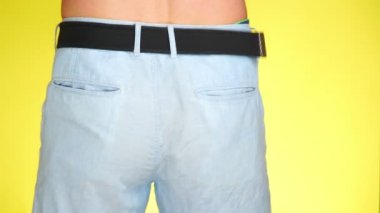 adam mavi şort sarı bir arka plan üzerinde dans. yakın çekim. 4k, ağır çekim